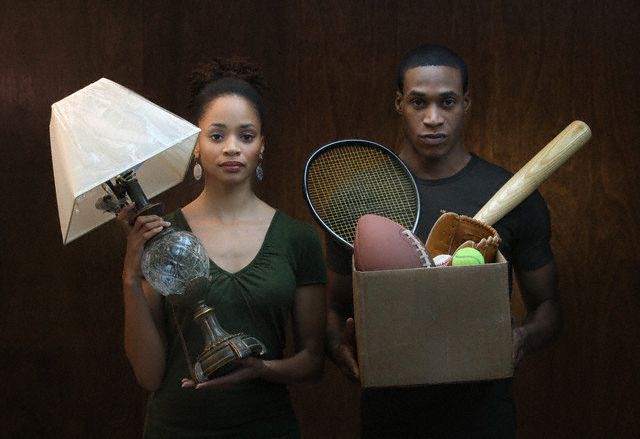 Woman holding lamp, man holding box with sports equipment